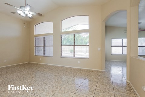 A spacious room with a fan and tiled flooring.