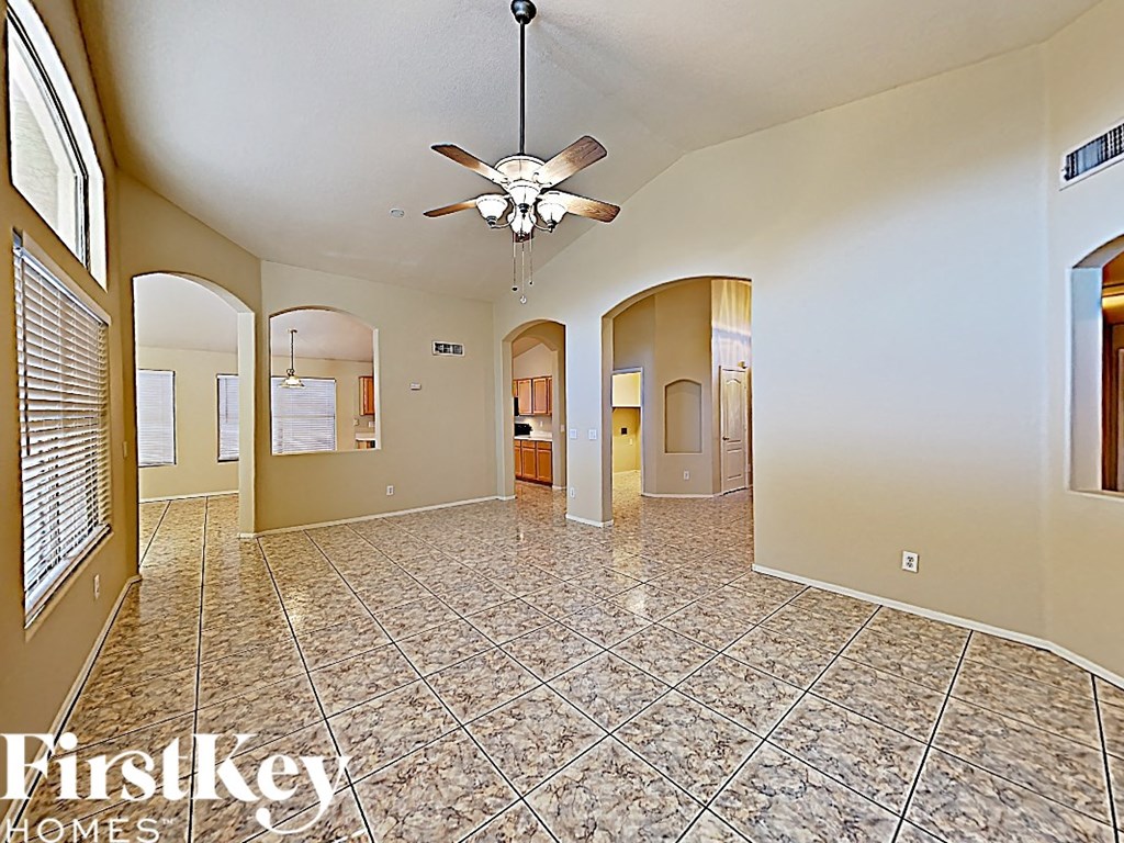 A spacious room with a fan and tiled flooring.