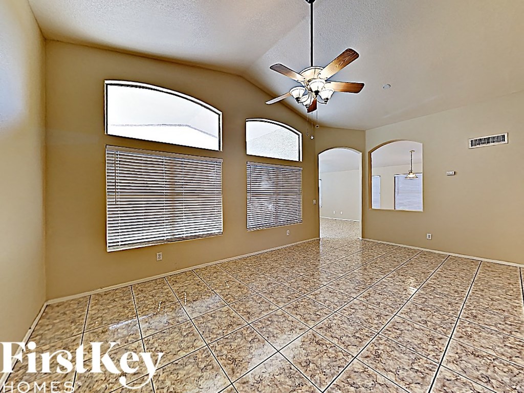 A spacious room with a fan and tiled flooring.
