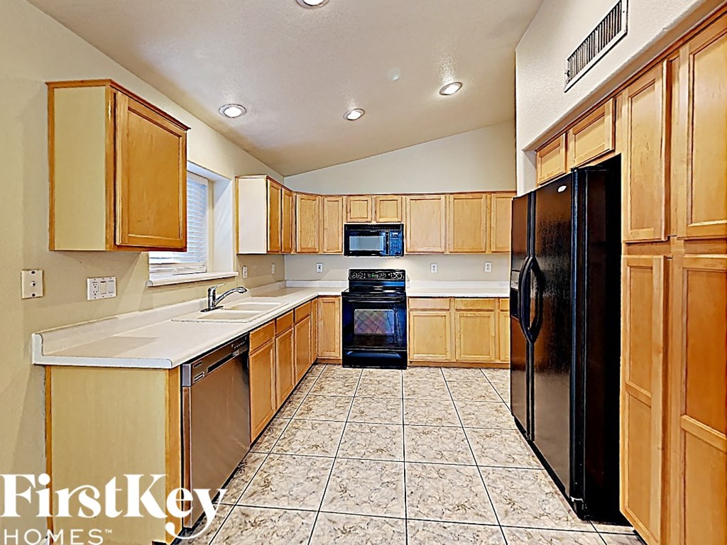 A kitchen with wooden cabinets and black appliances.
