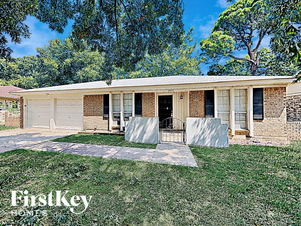 the front of a brick house with a yard and grass