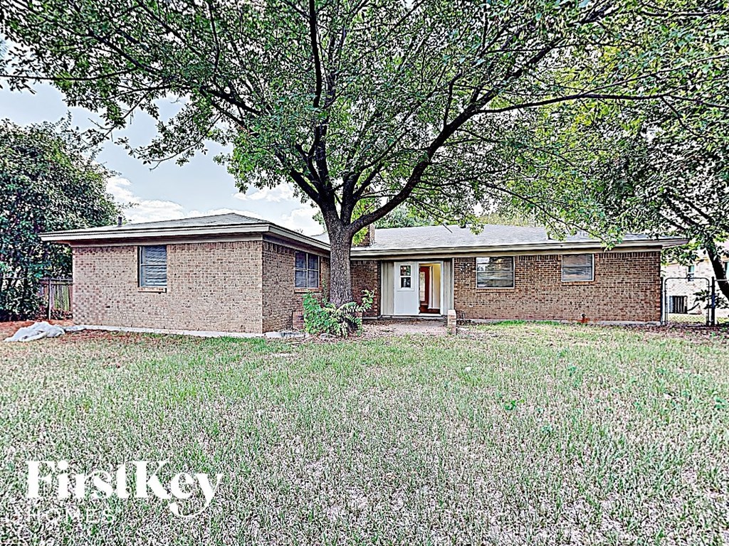 a small brick house with a tree in the yard