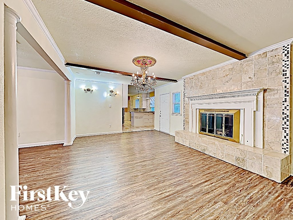 a large living room with a fireplace and wooden floors