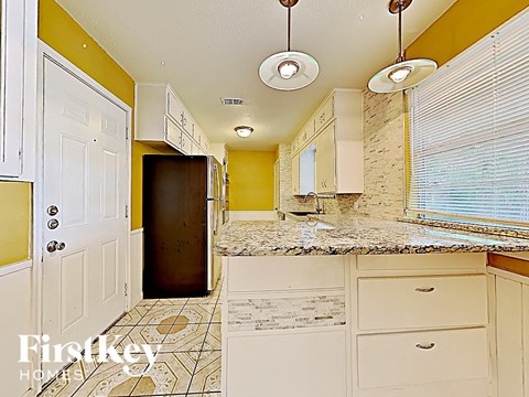 a kitchen with white cabinets and a counter top