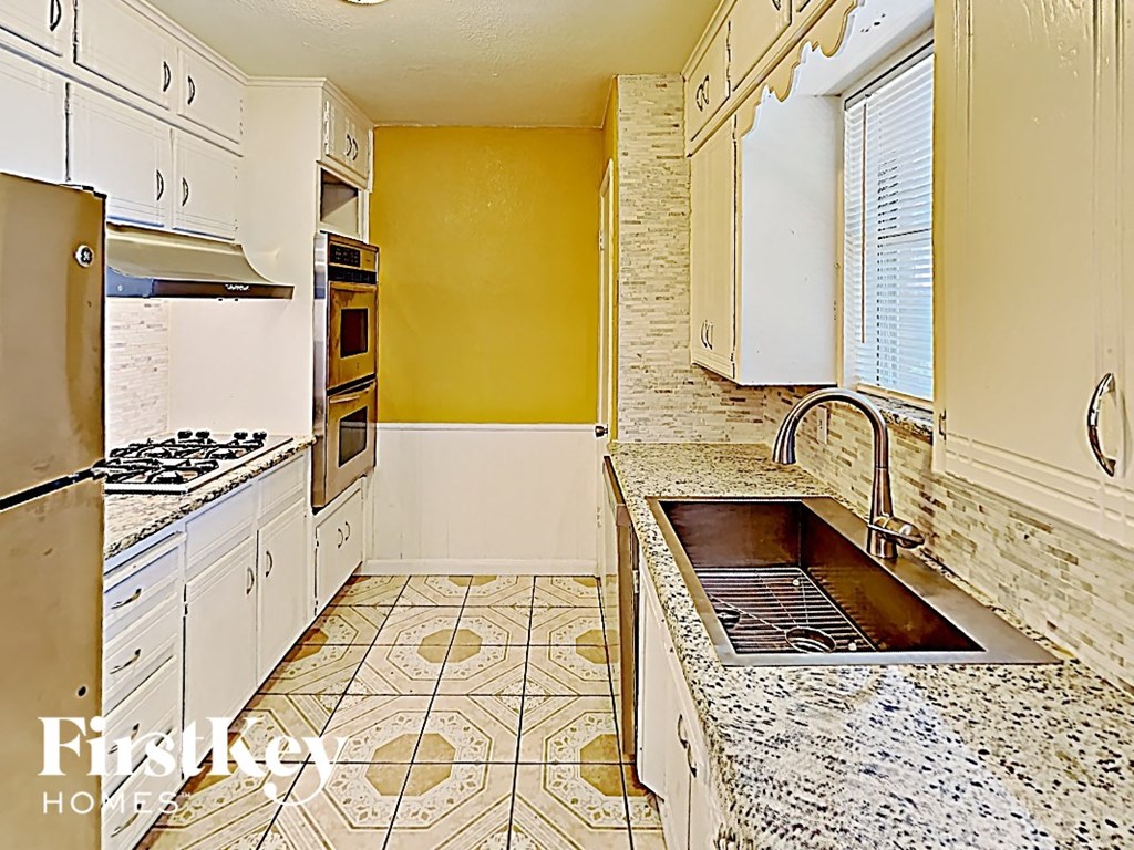 a kitchen with white cabinets and a sink