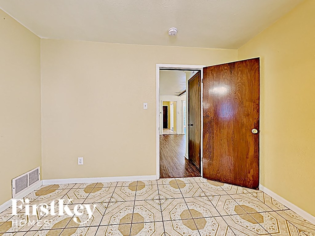 an empty room with a tiled floor and a wooden door