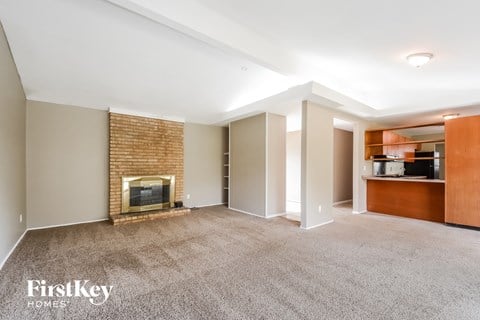 A spacious living room with a fireplace and built-in shelves.