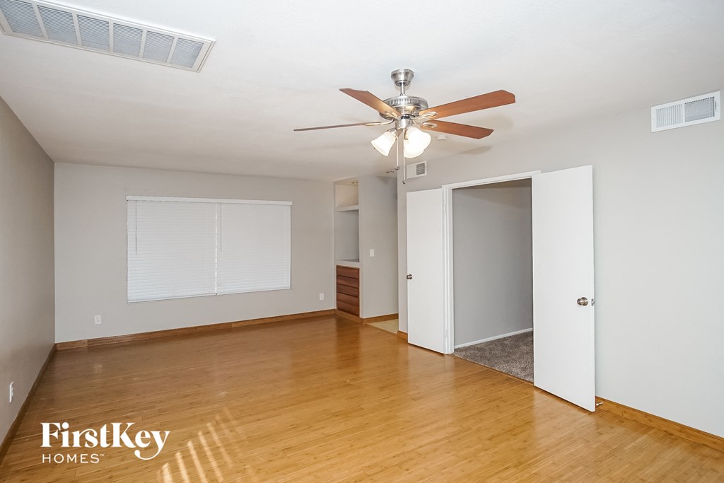 a living room with wood flooring and a ceiling fan