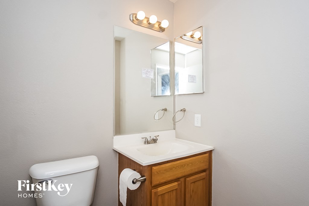 a bathroom with a toilet and a sink and a mirror