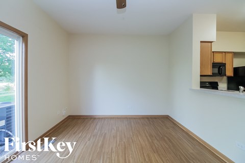an empty living room with wood flooring and a window