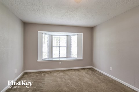 A room with a window and a carpet floor.