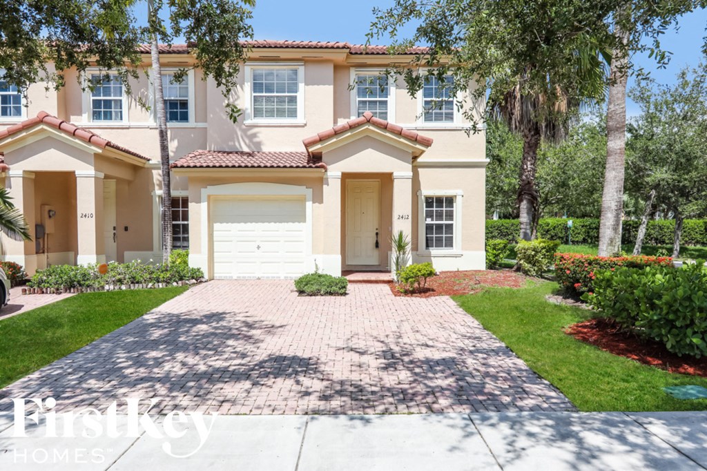 a beige house with a driveway and a garage door
