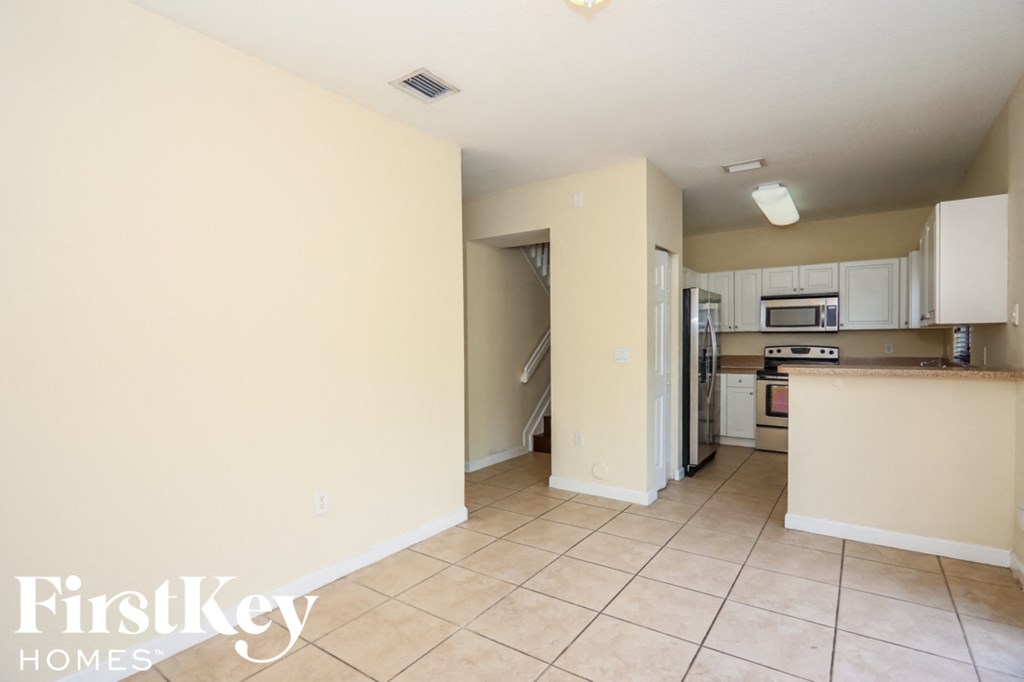 a large kitchen with a tiled floor and white cabinets