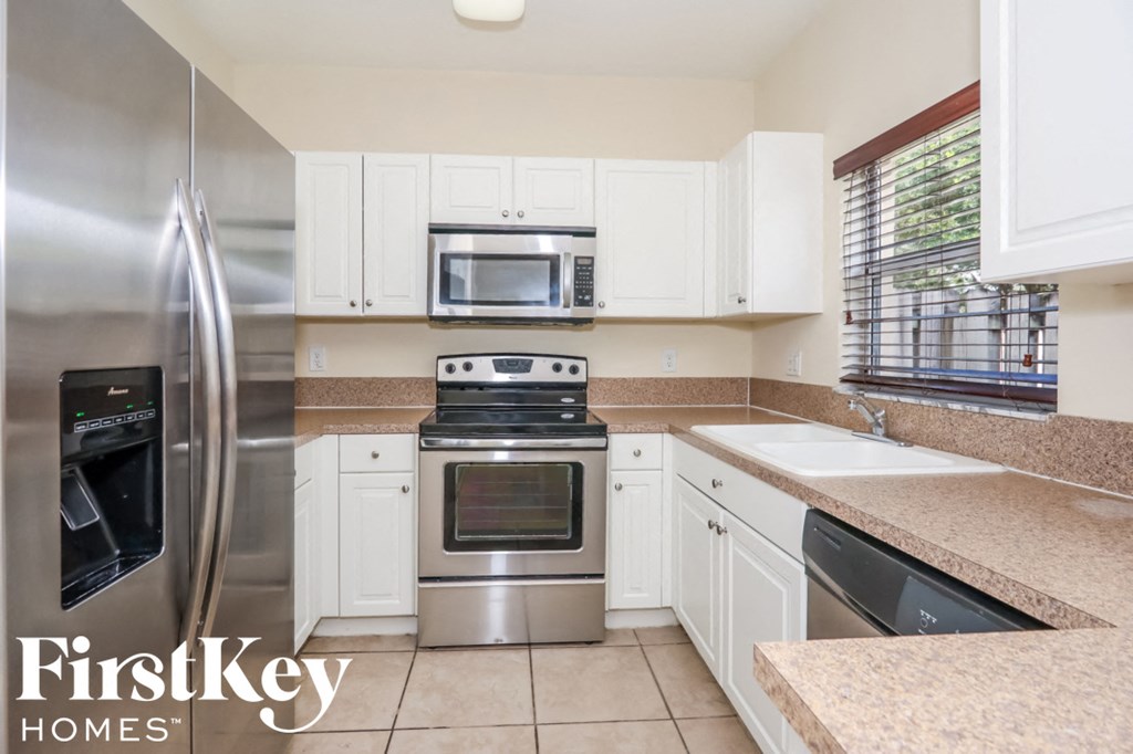 a kitchen with stainless steel appliances and white cabinets