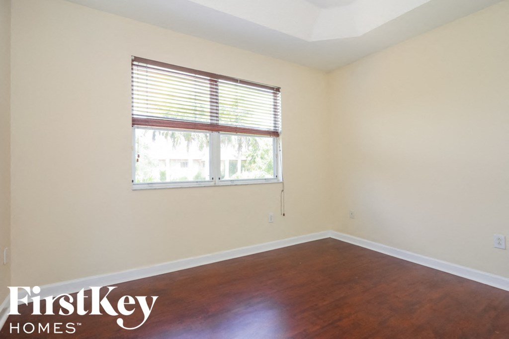 an empty room with wood floors and a window