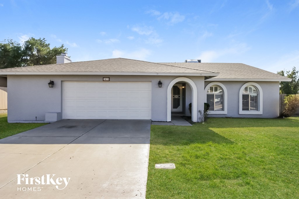 A house with a garage and a driveway in front of it.