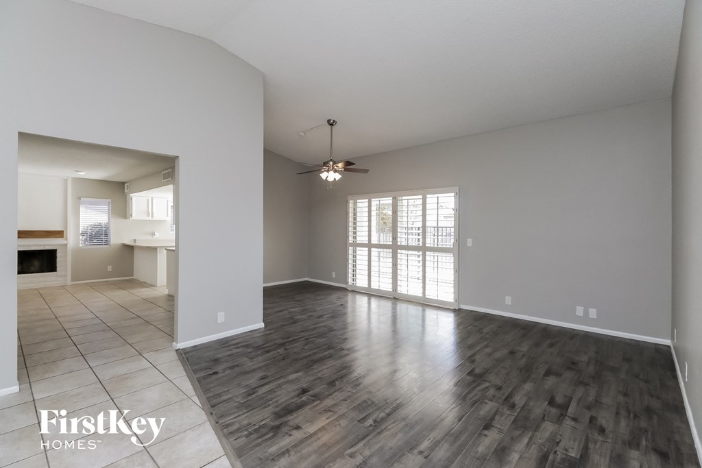 A spacious room with wooden flooring and a ceiling fan.