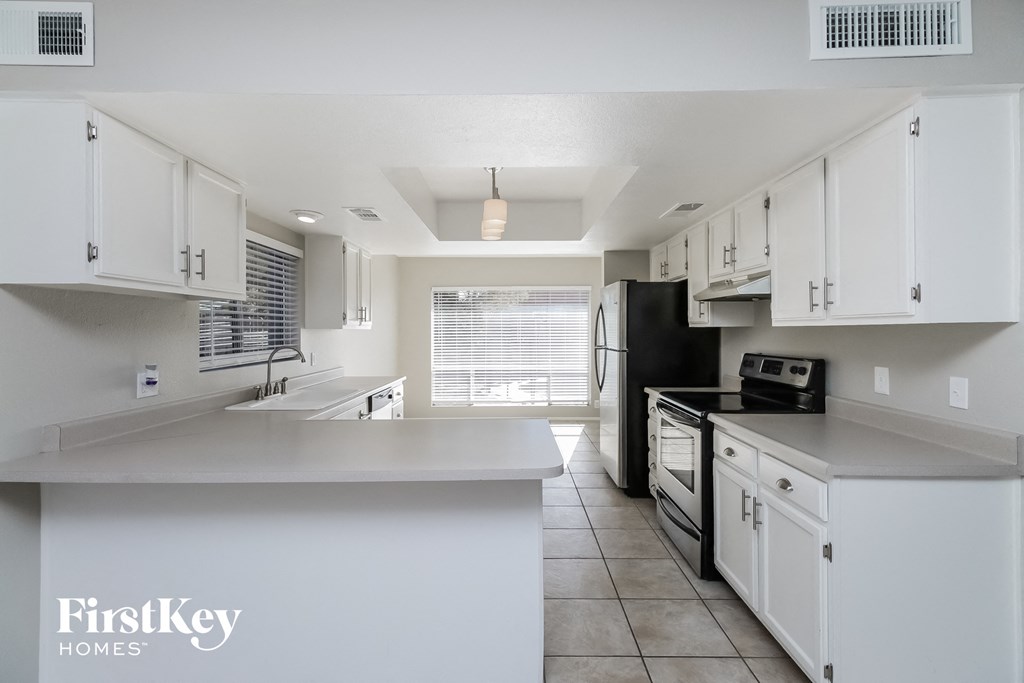 A kitchen with white cabinets and appliances.