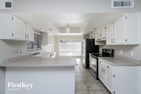 A kitchen with white cabinets and appliances.