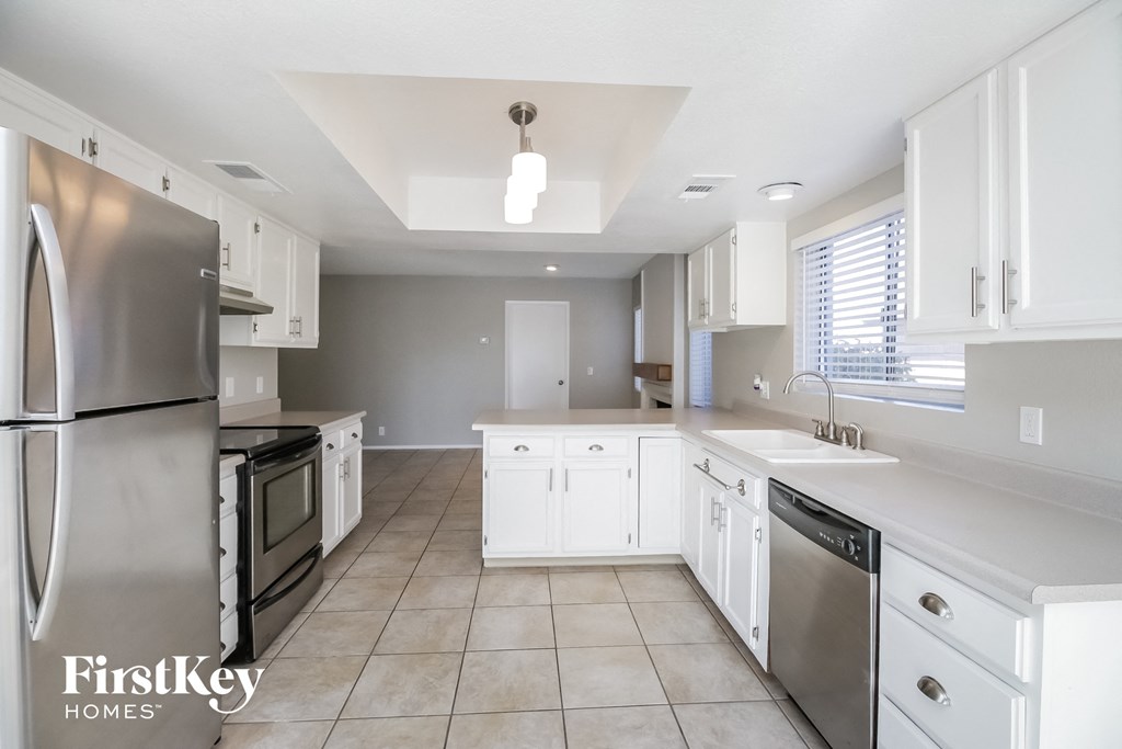 A kitchen with white cabinets and appliances is shown.