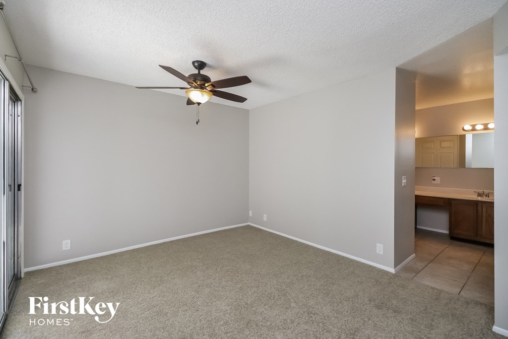 A room with a ceiling fan and a carpeted floor.