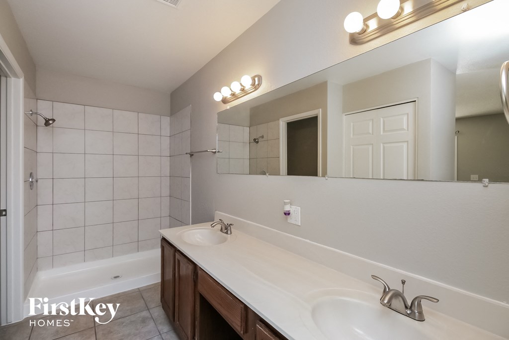 A bathroom with a white sink and a mirror above it.