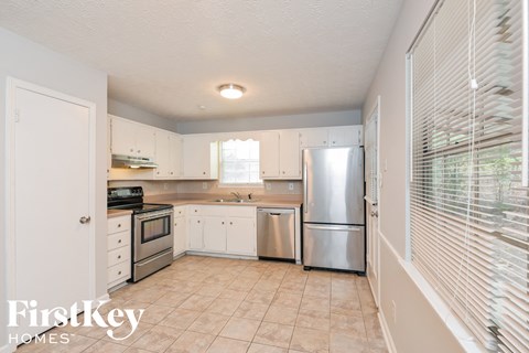 A kitchen with white cabinets and appliances is shown.