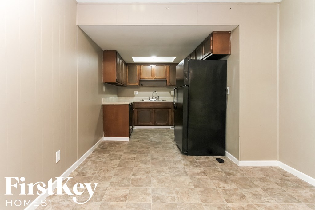 a kitchen with a refrigerator and a sink and cabinets