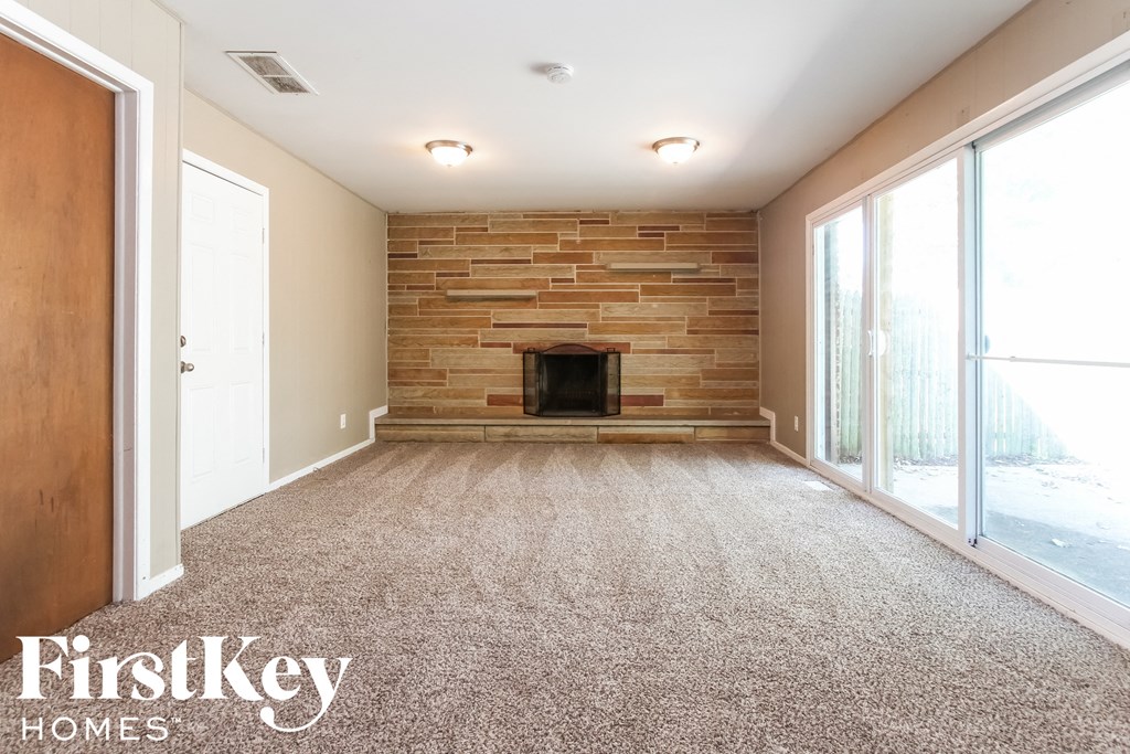 a living room with a fireplace and a carpeted floor