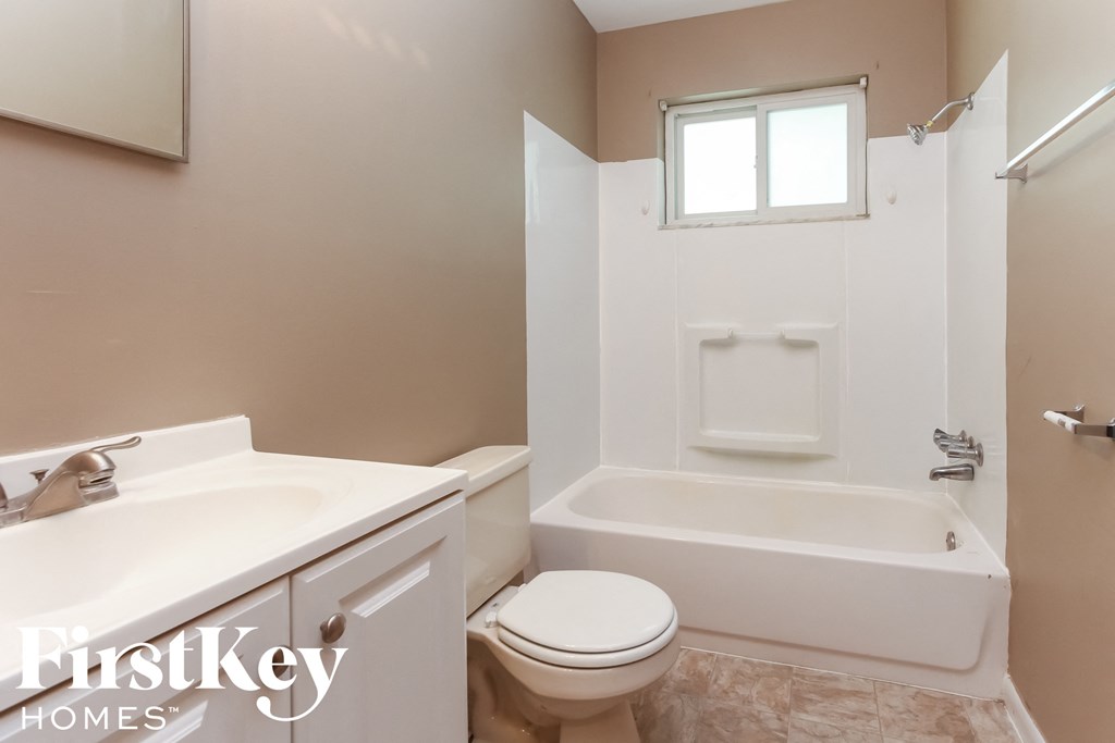 a bathroom with a toilet and a tub and a sink
