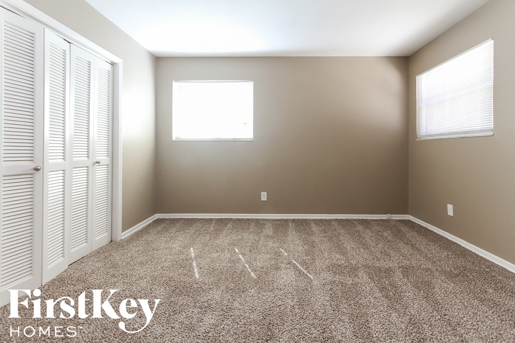 a empty room with carpet and a window