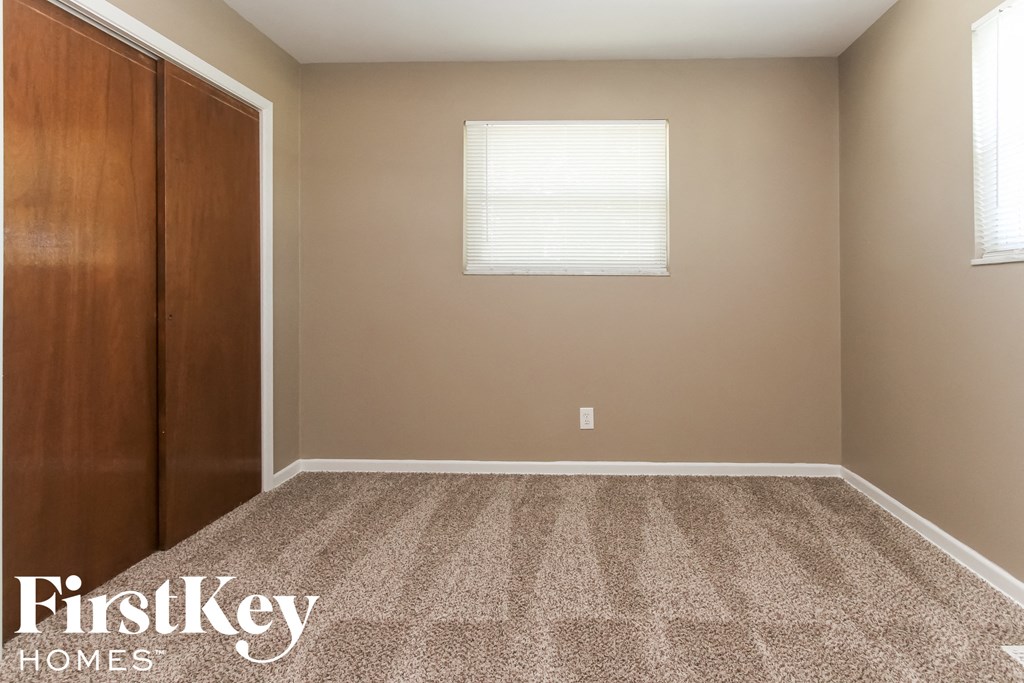 a empty room with carpet and a closet