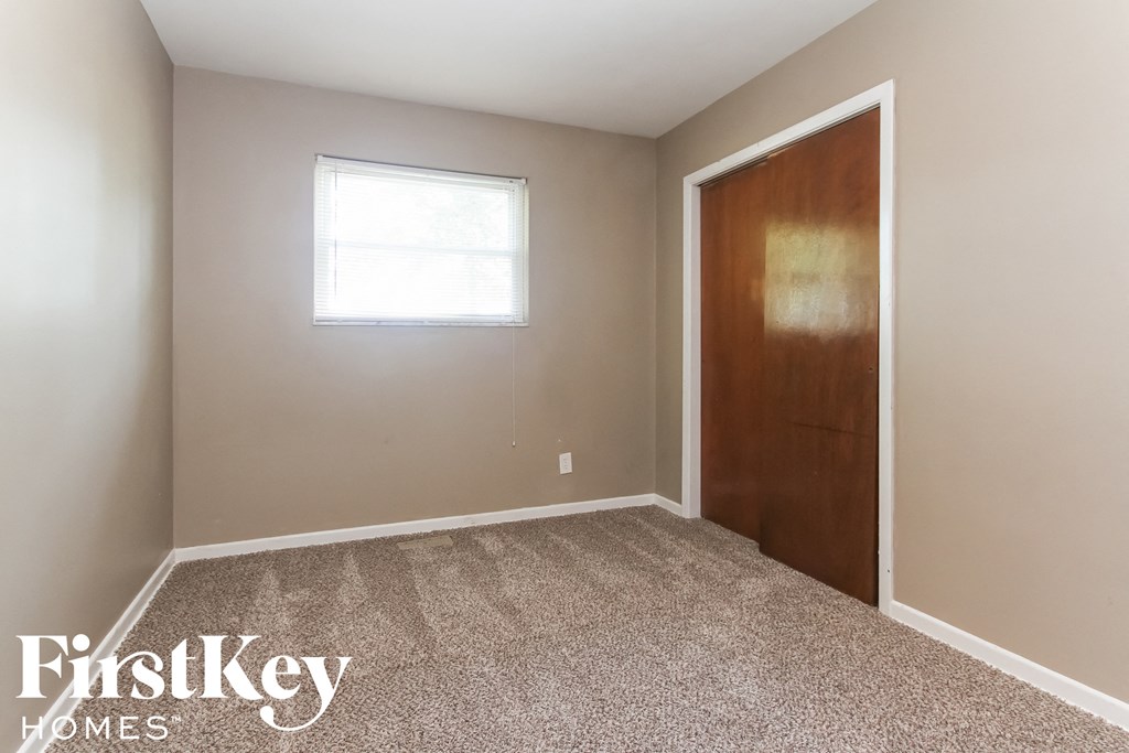 a room with carpet and a door and a window