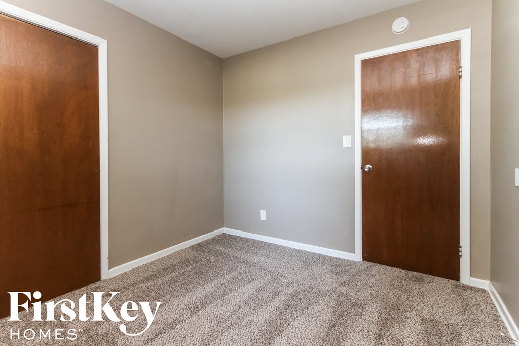 a bedroom with a carpeted floor and two doors