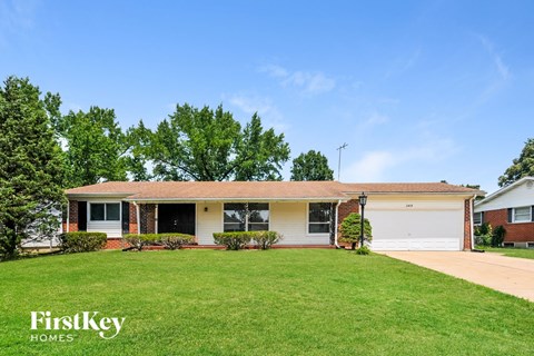 a home with a green lawn and a white house