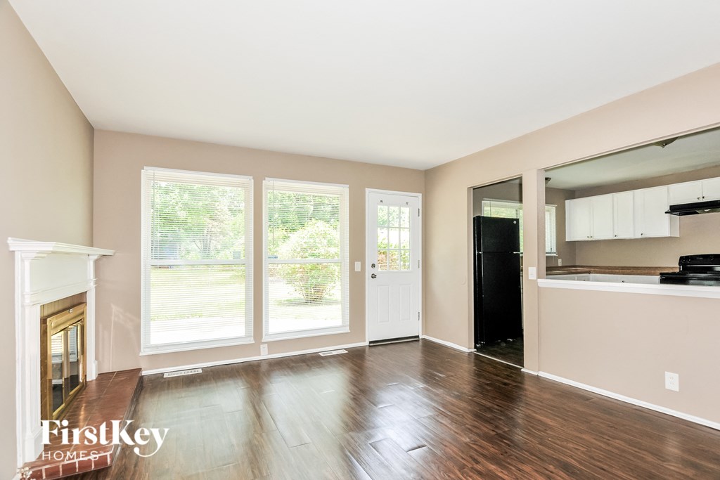 an empty living room with wood floors and a fireplace