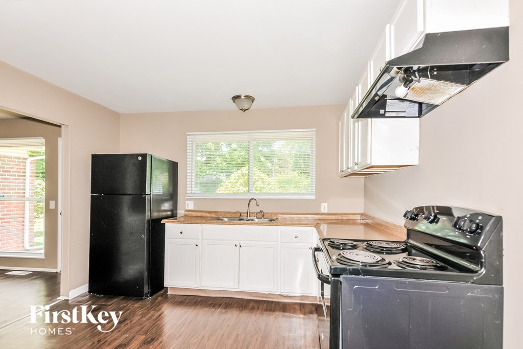 a kitchen with a stove and a refrigerator and a sink