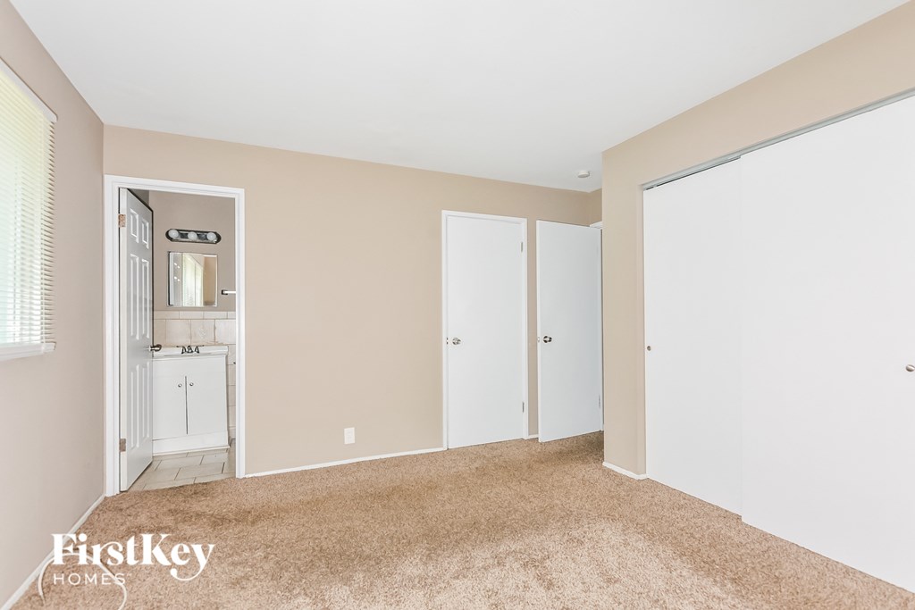 a bedroom with two closets and a door to a bathroom