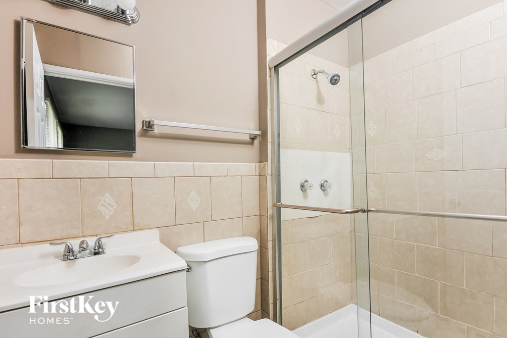 a bathroom with a shower and a toilet and a sink
