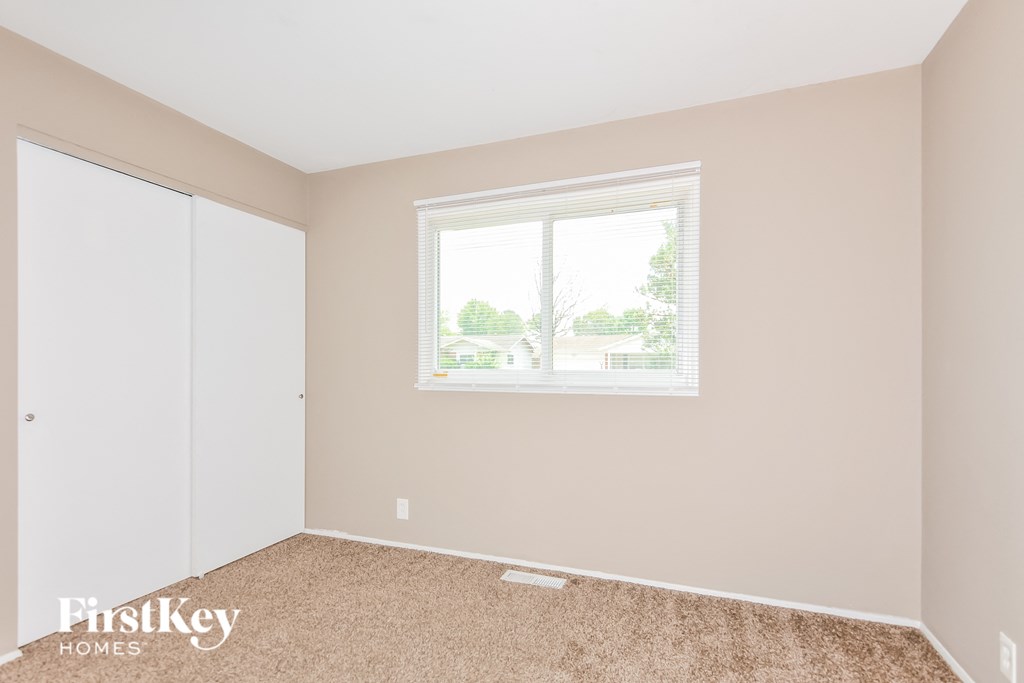 a bedroom with a window and a closet