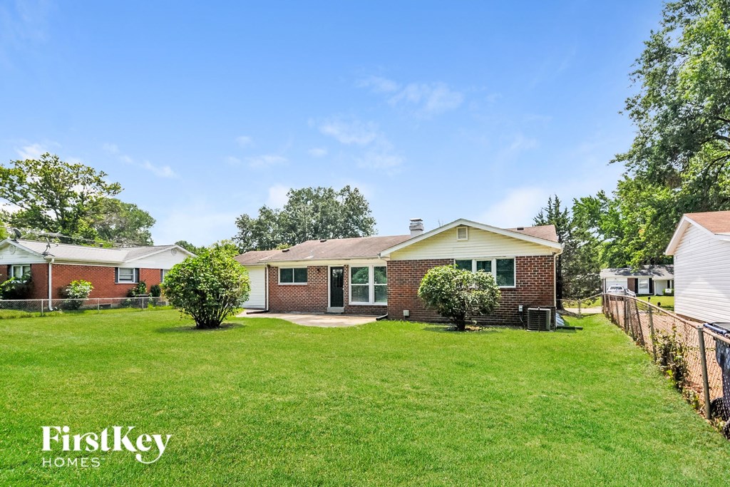 a backyard with a brick house and a green lawn