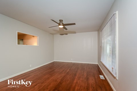 a living room with wood floors and a ceiling fan