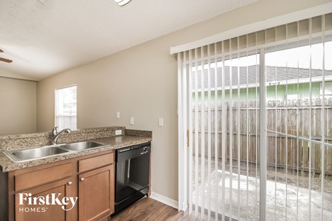 a kitchen with a sink and a window with a sliding glass door