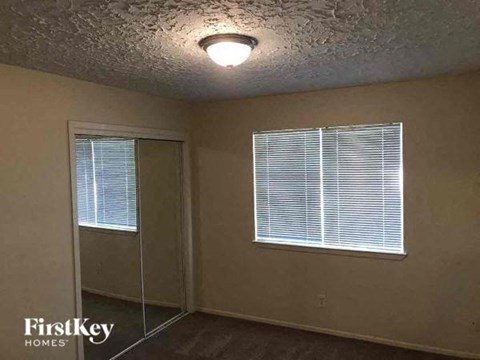 an empty room with a window and a ceiling light