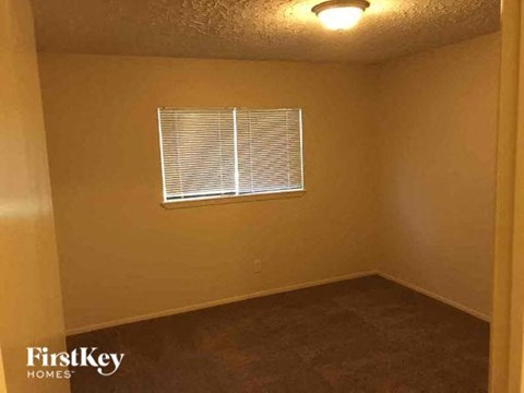 a small room with a window and a brown floor