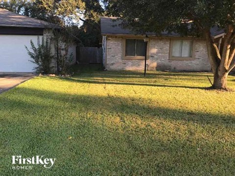 a yard in front of a house with a tree