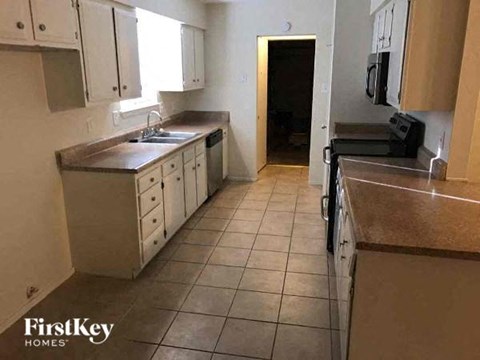 a kitchen with tiled floors and white cabinets