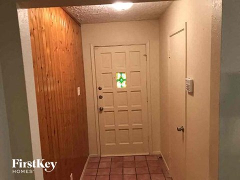 a hallway with a white door with a stained glass window