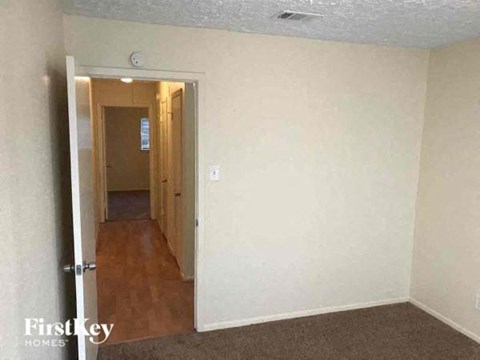 an empty living room with a door to a hallway