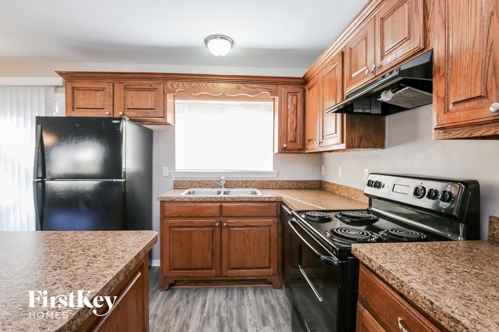 a kitchen with wooden cabinets and black appliances
